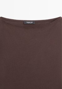 Donkerbruin shirt met ronde hals en een zichtbaar zwart label dat binnen in de kraag is genaaid met de tekst "Massimo Dutti Made in Morocco."