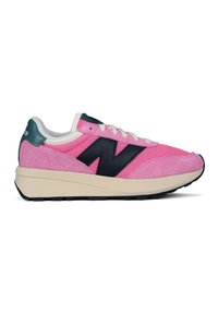 Pink sneakers featuring a mesh upper with suede accents, dark blue logo, white laces, and a cream-colored midsole. Textured rubber sole.