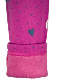 Roze stoffen legging met kleine donkerblauwe stippen en een hartpatroon; heeft een zacht roze fleecesmanchet en zichtbare stikseldetails.