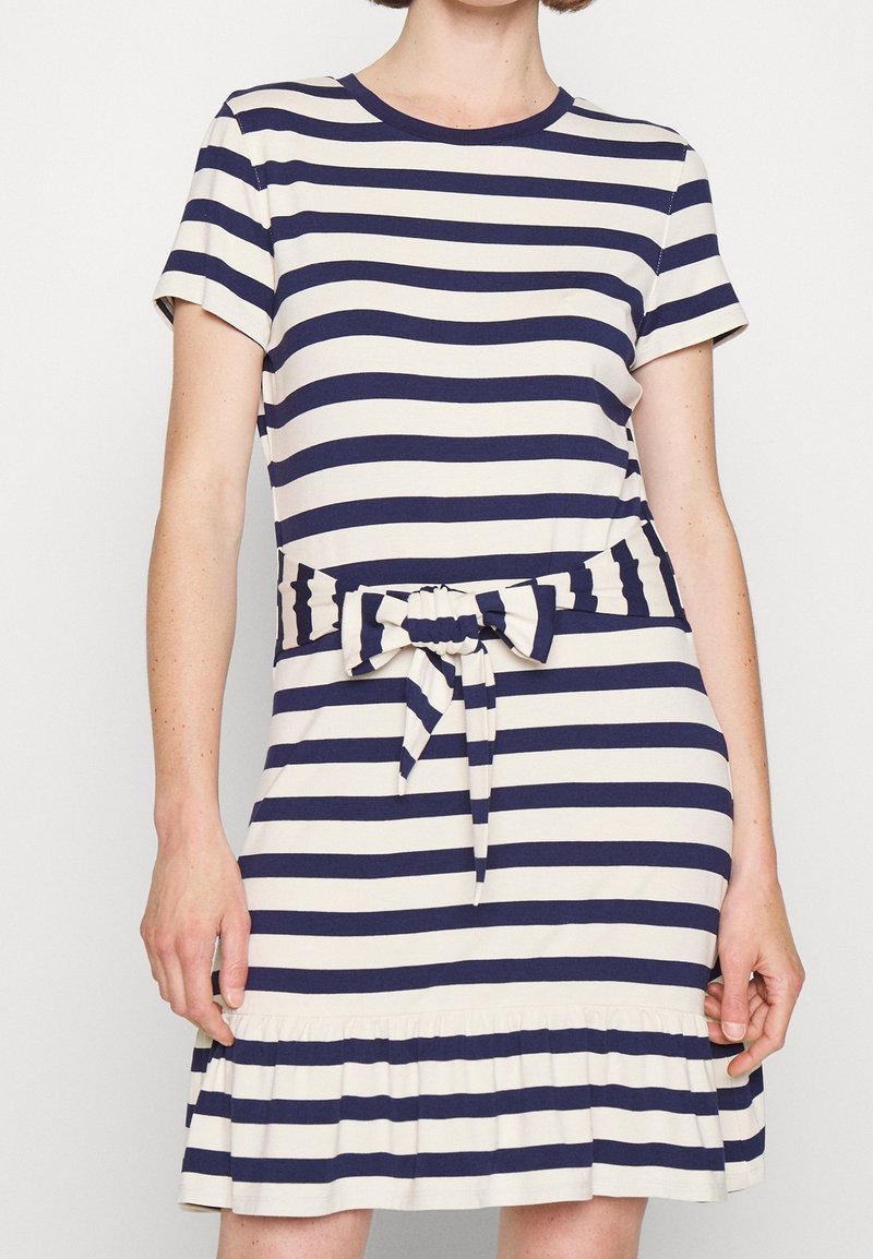 Pruhované šaty v krémové a námořnické modré barvě, s krátkými rukávy, kulatým výstřihem, opaskem v pase a volánkovým lemem. Měkká bavlněná tkanina.