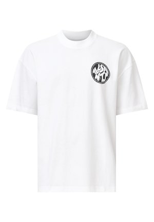 Weißes Baumwoll-T-Shirt mit einem runden schwarzen Logo auf der linken Brust, das stilisierte Texte und grafische Elemente zeigt. Lockere Passform und kurze Ärmel.