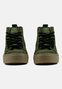 Zapatillas altas verdes hechas de tela texturizada con cordones negros, suela de goma beige y ojales de metal. Con un diseño de cuello acolchado.