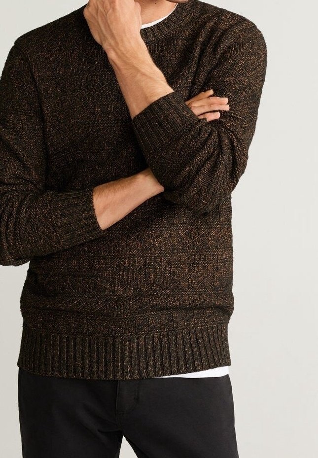 Strickpullover in dunkelbraun mit orangefarbenen und goldenen Flecken, runder Halsauschnitt, gerippte Bündchen und Saum, über einem weißen Hemd getragen.