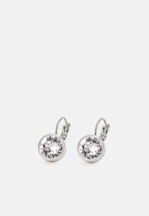 Boucles d'oreilles à levier rond en argent avec de grandes cristaux clairs facettés sertis dans des chatons en métal sur un fond blanc.