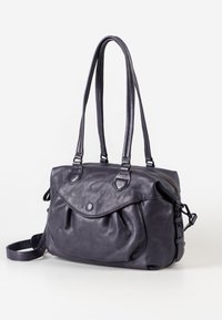 Borsa a mano in pelle viola con doppi manici, zip laterale e design con patta frontale. Caratterizzata da una texture liscia e accenti minimalisti e funzionali.
