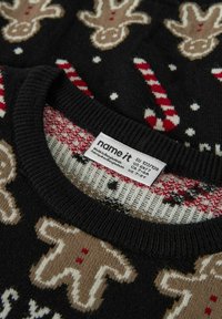 Maglione lavorato a maglia con omini di pan di zenzero e bastoncini di zucchero in beige, rosso e bianco su uno sfondo nero. Dettaglio del collo e dell'etichetta.