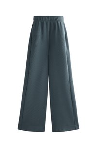 Pálené nohavice vo tlmenom odtieni teal s ribovanou textúrou. Vybavené elastickým pásom a uvoľneným strihom. Bez viditeľných vreciek.
