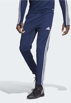 Navy athletic pants featuring white side stripes, elastic waistband, and a smooth texture. Includes an Adidas logo on the left thigh.
