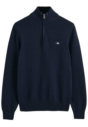 Navy blue pullover sweater made of soft fabric. Features a high neck with a zip and ribbed cuffs and hem, embellished with a small logo.