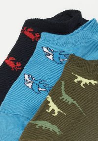 Trzy pary skarpetek: granatowe z czerwonymi krabami, niebieskie z niebieskimi rekinami, oliwkowe z zielonymi dinozaurami. Mieszanka bawełny, tekstura prążkowana, długość do kostki.