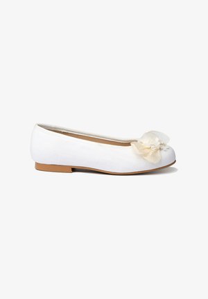Zapato de ballet plano blanco con tacón bajo y decoración floral crema en la punta, sobre un fondo blanco.