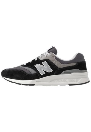 Czarno-szary sneaker New Balance z białym logo "N", białymi sznurówkami oraz grubą białą podeszwą z wypukłym napisem "new balance" po boku.