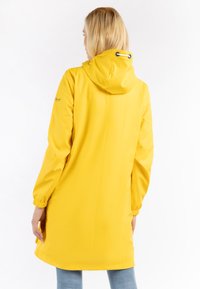 Impermeabile giallo con cappuccio regolabile, polsini elasticizzati e design di lunghezza media. Texture liscia e linee semplici.