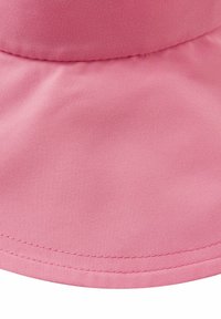 Cappello a secchiello rosa in tessuto caratterizzato da una texture morbida e liscia, una corona arrotondata e una visiera larga e inclinata verso il basso, con cuciture ordinate lungo il bordo.