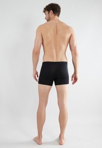 Zwarte boxershorts van zacht, rekbaar materiaal, met een comfortabele tailleband en een ontwerp tot halverwege de dijen.