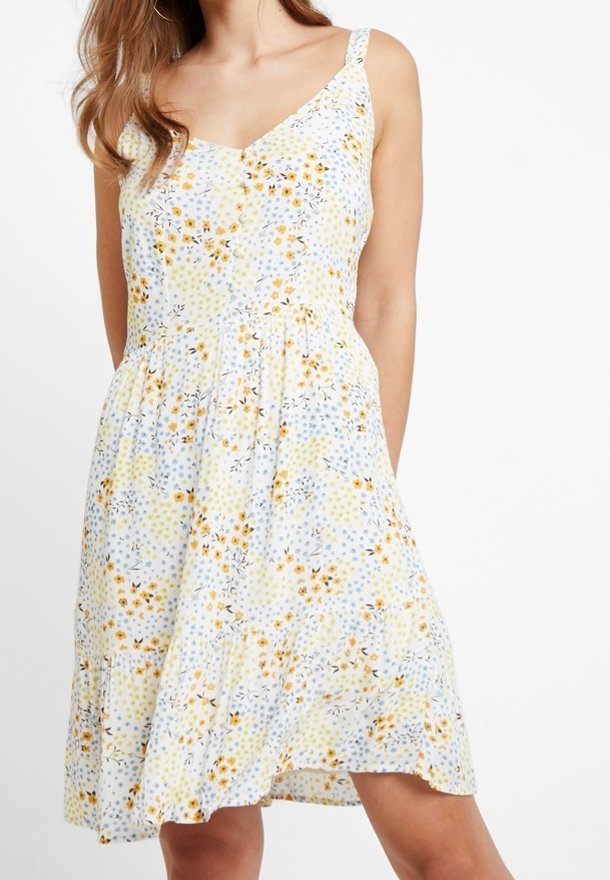 Blommig klänning med ett mönster i gult, blått och vitt, V-ringning, tunna band och en utsvängd kjol med rynkad midja. Bomullstyg.