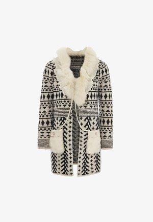 Melnā un baltā rakstu džemperis ar mākslīgo kažokādu apkakli, kam ir divas priekšējās kabatas ar viļņotām malām un pogām.