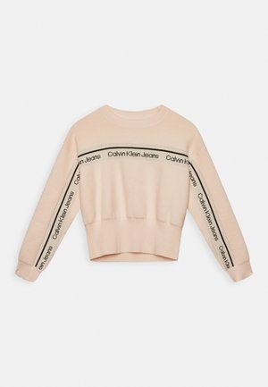 Suéter corto de color rosa claro con textura acanalada, con franjas negras del logo "Calvin Klein Jeans" en las mangas y en el pecho.