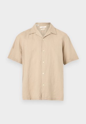 Férfi rövid ujjú, bézs gombos ing tábori gallérral, fehér háttéren laposan elhelyezve.
