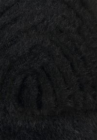Fil noir et duveteux avec une surface texturée, enroulé en forme de spirale. Les fibres sont épaisses et densément serrées, offrant une apparence douce.