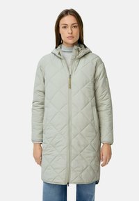 Lys grå quiltet lang frakke med hætte, der har en fuld lynlås og et minimalistisk design. Blødt stof og horisontal tekstur.