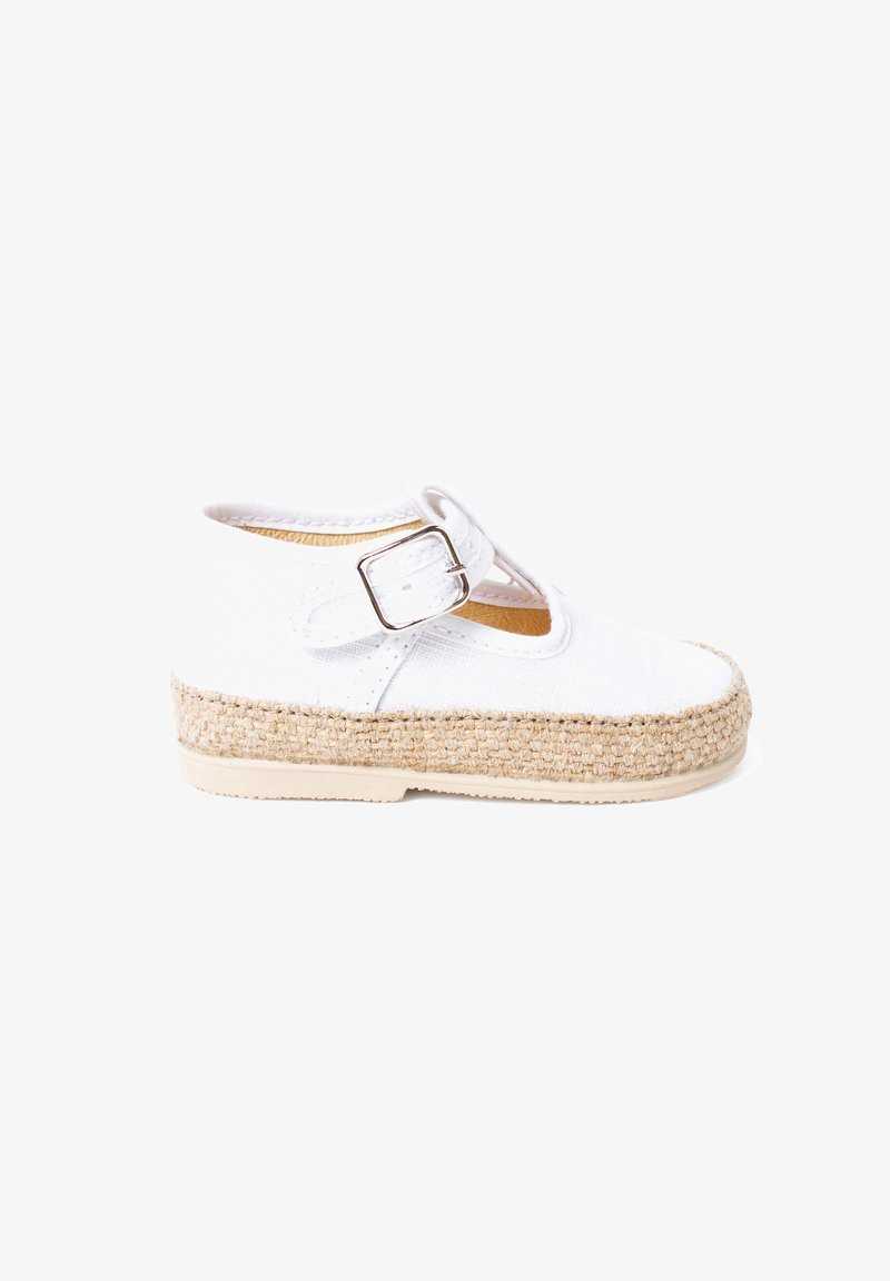 White canvas shoe with a jute-wrapped sole. Features a single strap with a silver buckle. Rounded toe design, minimalistic appearance.