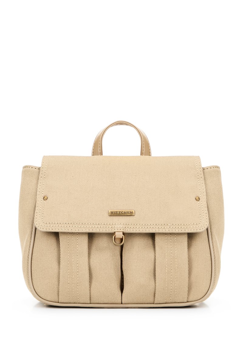 Mochila de tela beige con cierre tipo solapa, detalles de hardware dorado, parte delantera plisada y asas superiores. Presenta una placa de logo en la parte frontal.