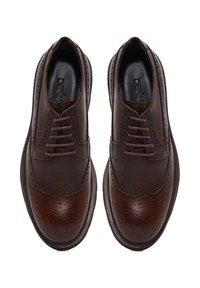Une paire de chaussures brogue en cuir poli marron foncé avec des détails en bout d'aile et des orteils ronds, vue de dessus sur un fond blanc.