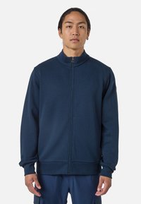 Felpa con zip blu navy, colletto alto, polsini a costine e una texture liscia. Presenta un piccolo logo sulla spalla sinistra.