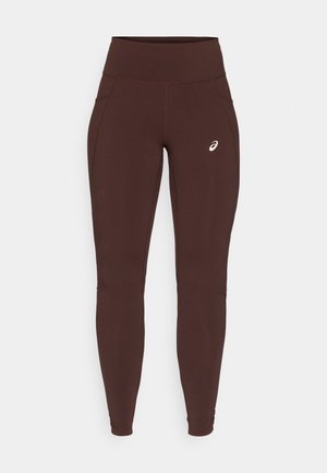 Leggings marroni in tessuto elasticizzato con vita alta, dotati di tasche laterali e di un logo discreto sulla coscia sinistra.