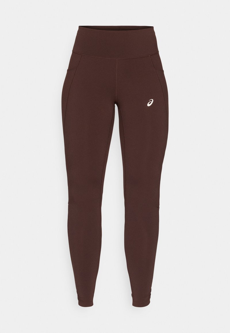 Bruine legging gemaakt van rekbare stof met een hoge tailleband, voorzien van zijzakken en een subtiel logo op de linkerdij.