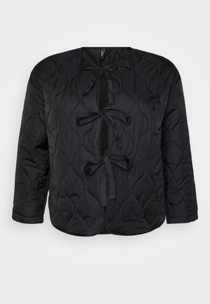 Melna pārsēta jaka ar apaļu kakla izgriezumu, garām piedurknēm un trim dekoratīvām lentēm priekšpusē. Gluda, viegla auduma ar maigu tekstūru.