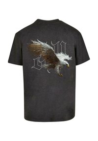 Mørk grå t-shirt med et stort grafik af en ørn i flugt på ryggen, med detaljerede fjer og stiliseret tekst under billedet.