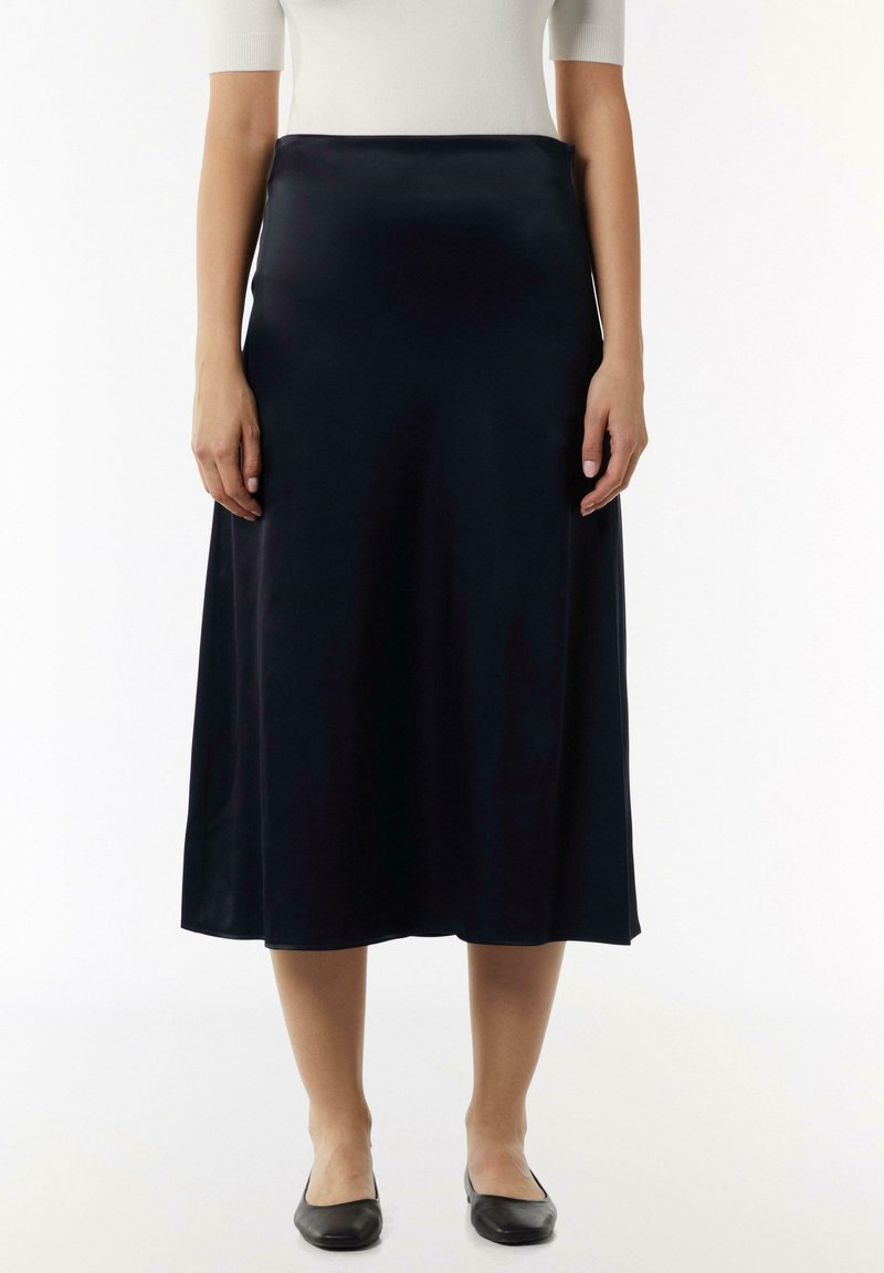Navy Satin-Midi-Rock mit glatter Textur, A-Linien-Design und einfarbig, kombiniert mit schwarzen Ballerinas.