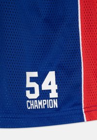 Plavi mrežasti sportski dres s crvenim i bijelim bočnim panelima, s velikim bijelim brojem "54" i ispisanom riječju "ČAMPION" ispod.