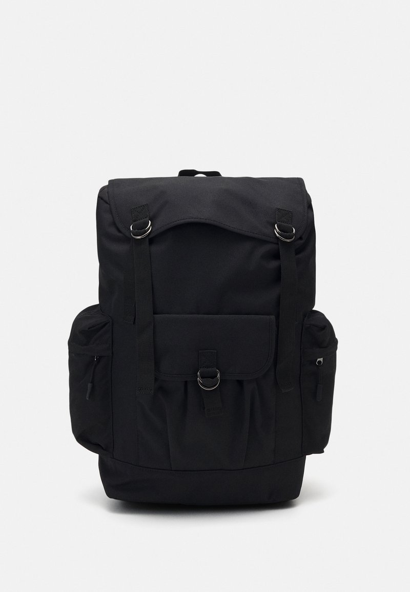 Sac à dos en tissu noir avec rabat supérieur, poche avant avec boucle, deux poches latérales zippées et bretelles réglables.
