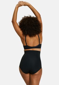 Conjunto de lencería negra que incluye un sujetador suave con tirantes ajustables y braguitas de cintura alta, ambas con un acabado mate y diseño sin costuras.