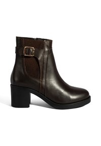 Bruine leren enkelboot met een stevige zwarte hak, elastische zijpaneel en een decoratieve gespaccent. Gladde afwerking met gestikte details.