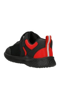 Scarpa sportiva nera e rossa con tessuto in rete, lati imbottiti, cinturino regolabile e suola in gomma testurizzata. Presenta un'accento riflettente sul tallone.