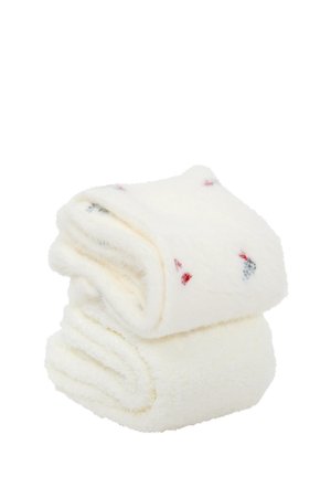 Toallas blancas esponjosas apiladas, con pequeños patrones rojos y azules. Textura suave y sensación mullida, ideales para secar y para el confort.