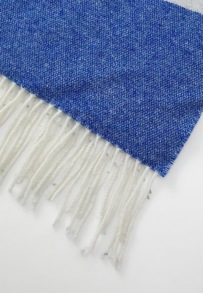 Material textil împletit albastru cu un model texturat, având ciucuri albi la margine. Textură moale, formă rectangulară și un gradient bogat de culoare albastră.