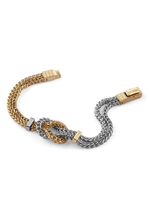Gold and silver woven chain bracelet featuring a twisting design, interlocking links, and branded clasps with "GUESS" engraved.