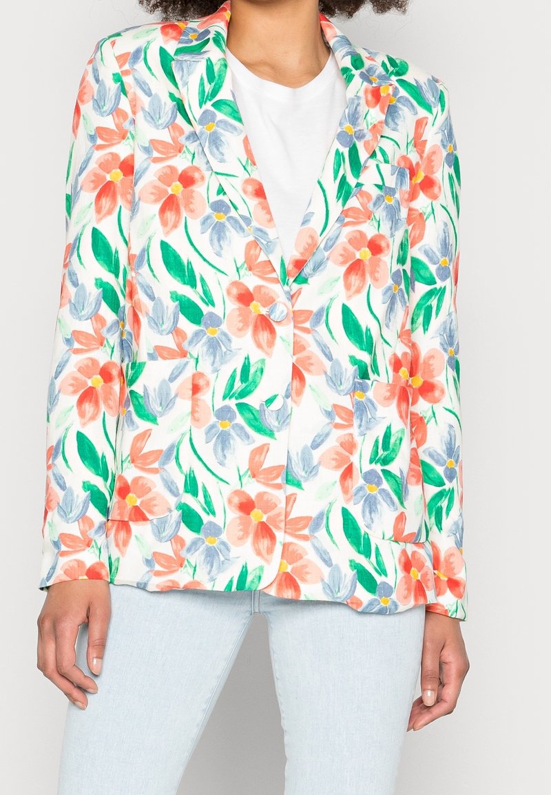 Kwiatowy blezer w kolorze białym, zdobiony żywymi pomarańczowymi i niebieskimi kwiatami z zielonymi liśćmi. Zapinany na jeden guzik, z wyciętymi klapami oraz naszywanymi kieszeniami.