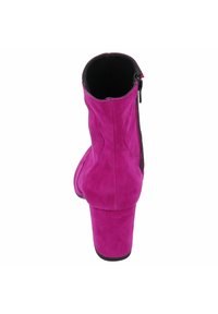 Botín de ante rosa hasta el tobillo con punta redonda y un tacón bloque moderado. Cuenta con una cremallera lateral y un forro interior suave.