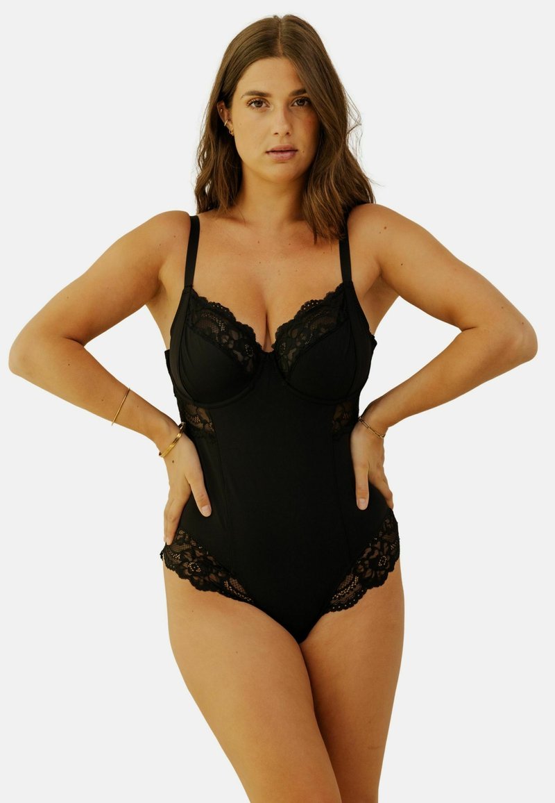 Bodysuit noir avec des accents en dentelle, bonnets à armatures, bretelles ajustables et texture lisse. Présente des côtés ouverts avec des détails en dentelle complexes.