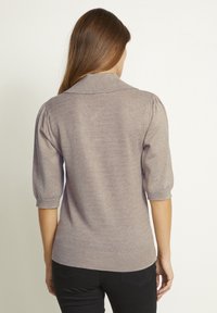Maglione lavorato a maglia marrone chiaro con colletto, maniche a sbuffo tre quarti e motivo testurizzato sul retro. Vestibilità casual, tessuto morbido.