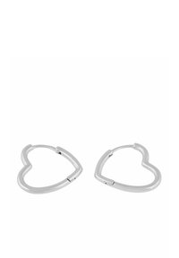 Ett par hjärtformade hoops i silverfärg med gångjärnsstängning mot en vit bakgrund.