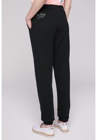 Soccx MIT GLITTER PRINT - Pantalones deportivos - black