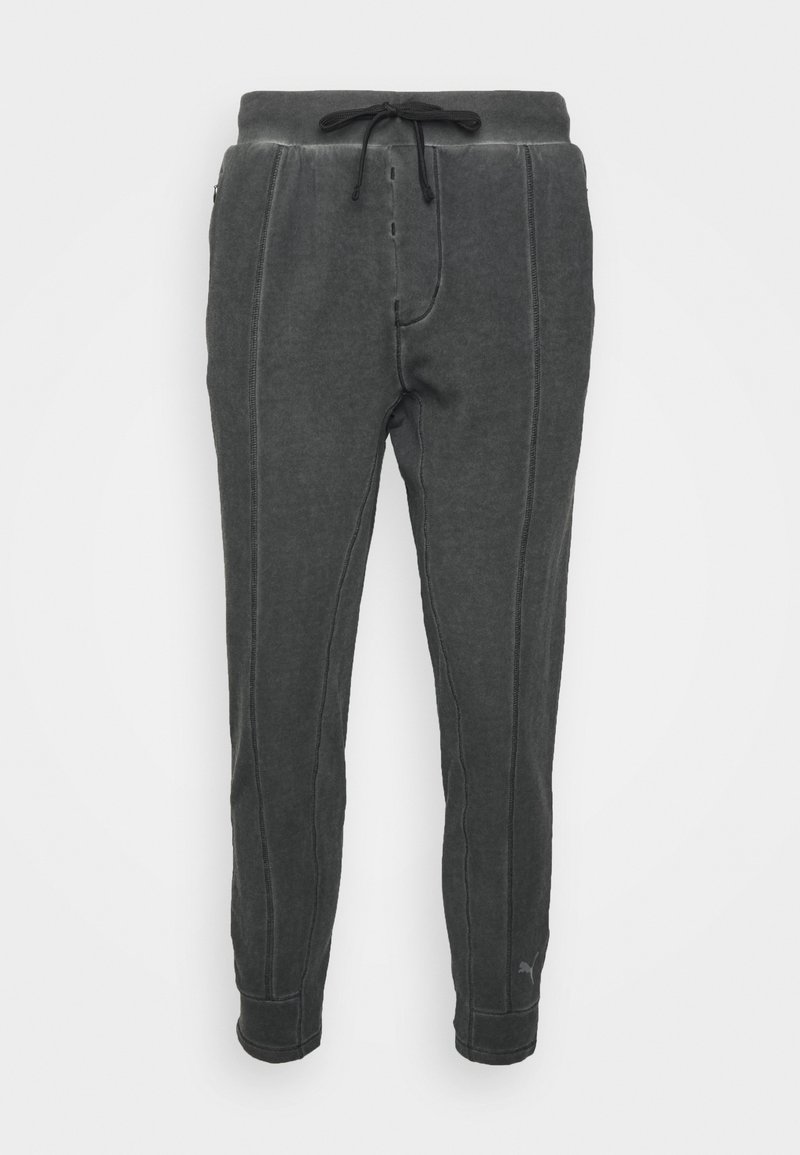 Pantalon de survêtement gris foncé fuselé avec détails de couture frontale, taille élastique avec cordon de serrage noir, et chevilles resserrées.