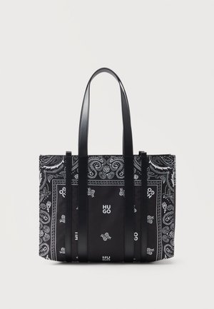Sac cabas noir et blanc avec imprimé paisley et floral bandana, deux longues anses noires et logo "HUGO" au centre devant.